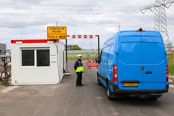 Portiersloge met portier en chauffeur die incheckt op bouwplaats