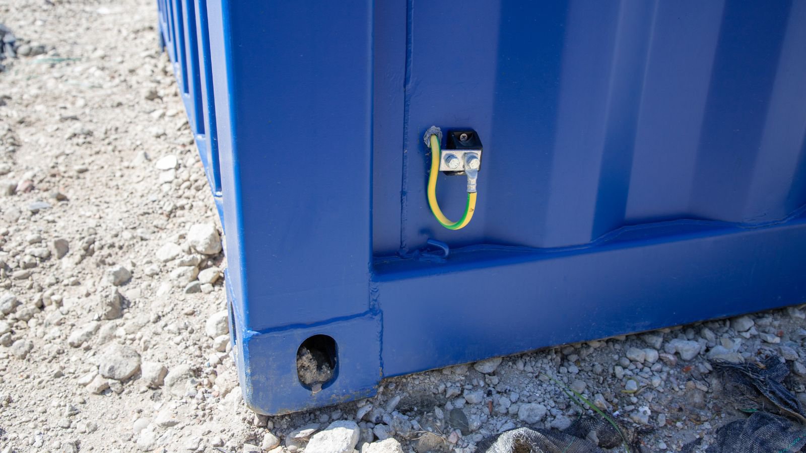 De aarde van een bouwmeterkast 250A zit bevestigd aan de zijkant van de container.